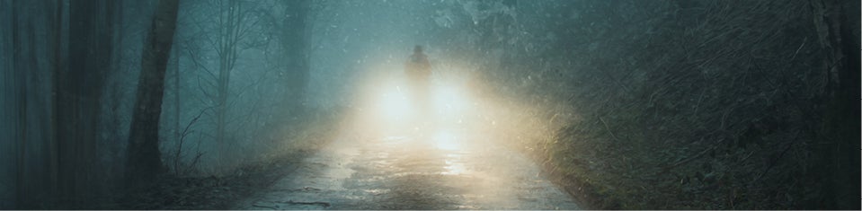 blurry figure in front of car headlights