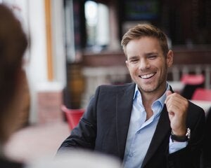 Man in a suit, sat across from someone else