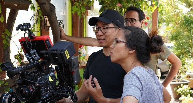 Man and woman look at film camera