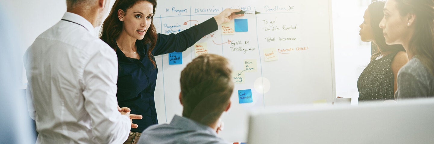 business woman giving presentation to coworkers