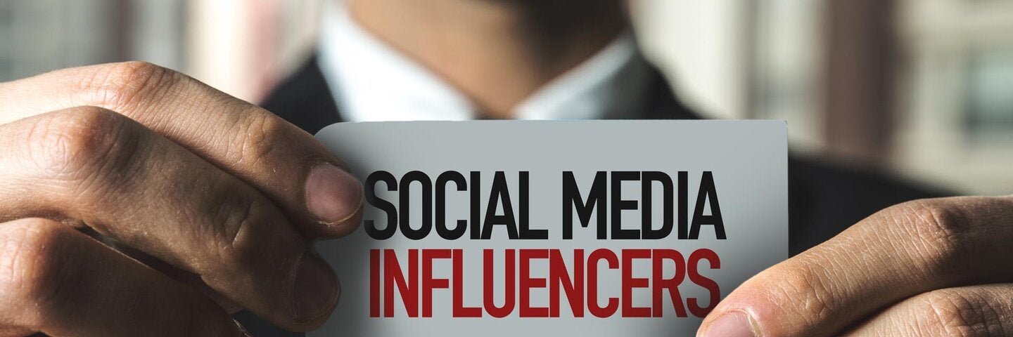 man holding card with text that reads "social media influencers"