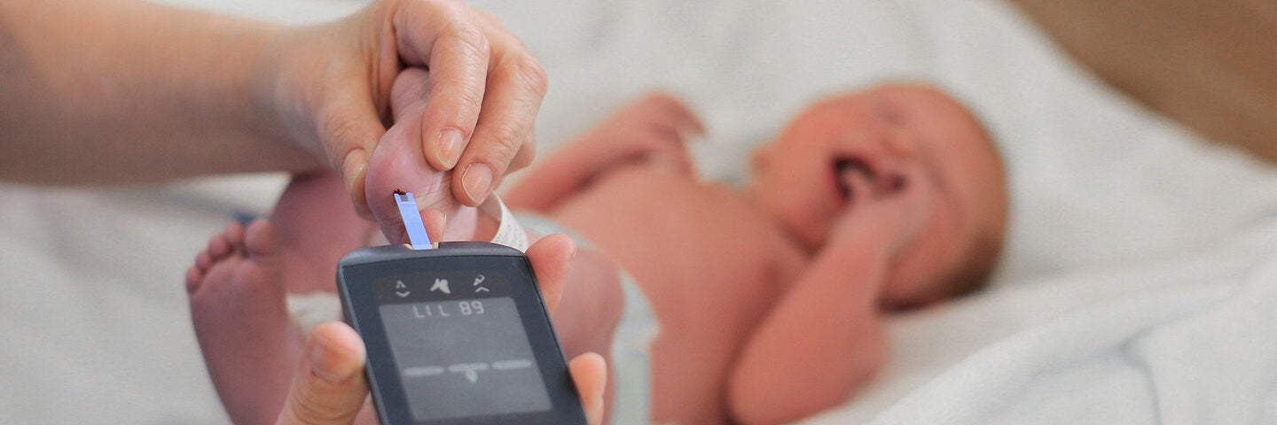  Pediatrician administers a heel prick test on a newborn baby