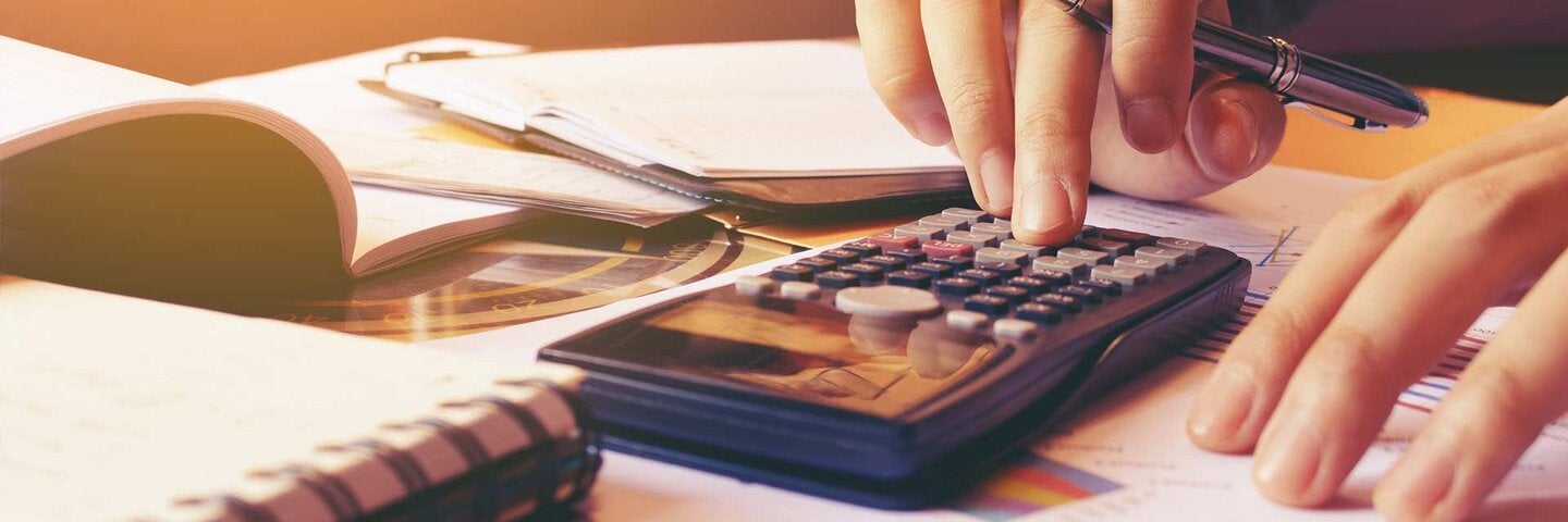 Woman using calculator with doing finance at home office.