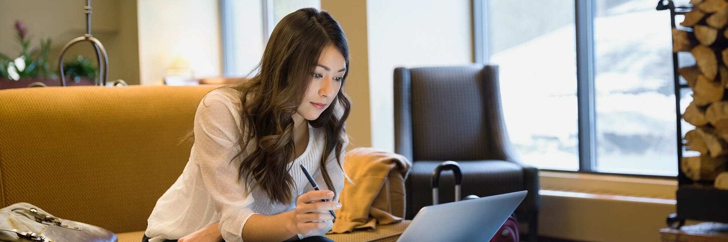 Businesswoman working at laptop in lobby