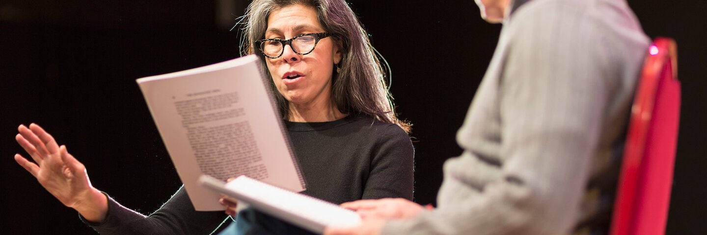 two actors stage reading sitting on chairs