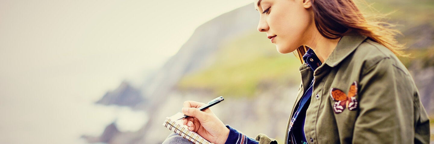 Woman writing cliffside