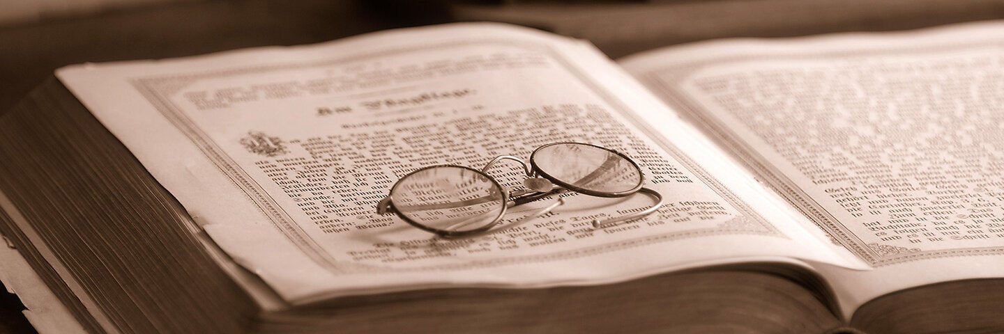 Reading glasses resting on a rare book