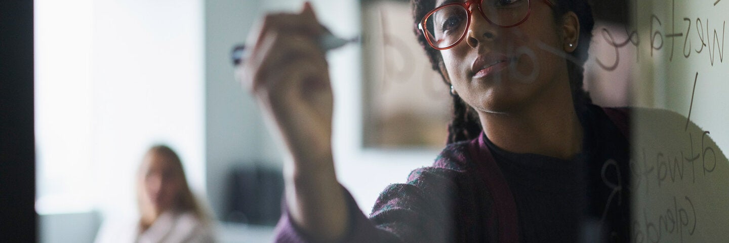 Woman brainstorming on a white board