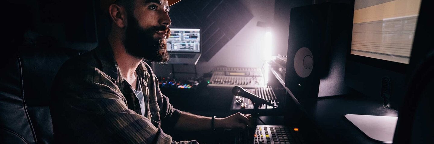DJ working in music studio and looking at computer screen