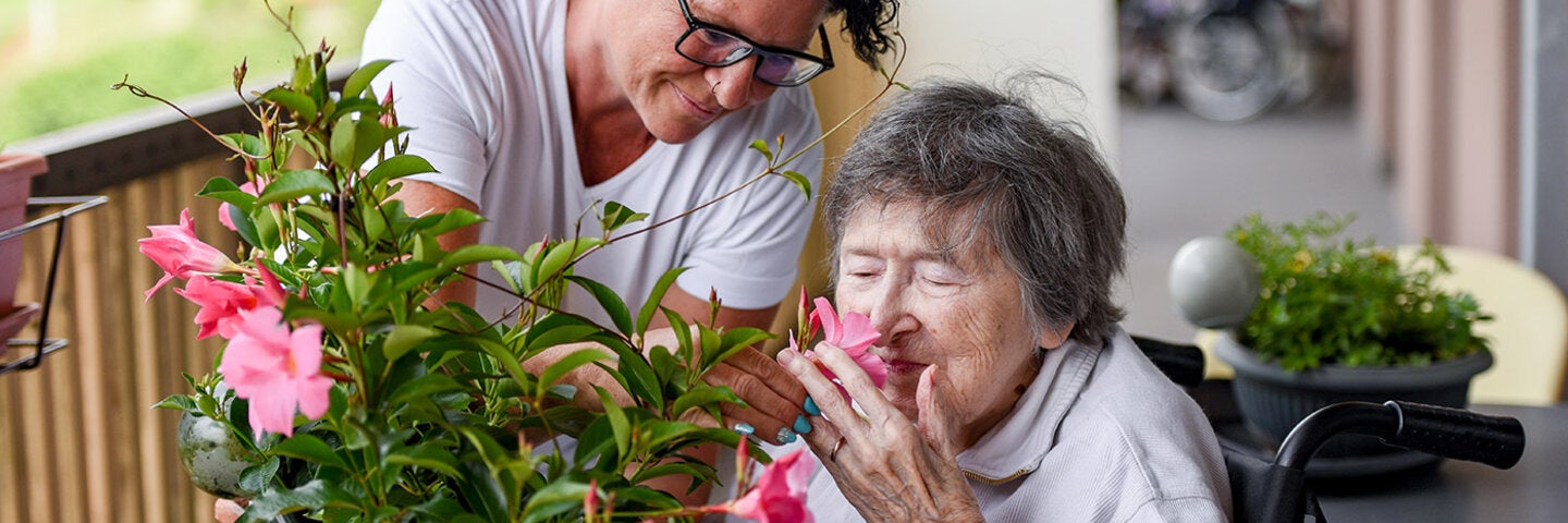 older person smelling flowers