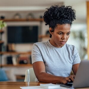 Concentrating adult woman working on laptop