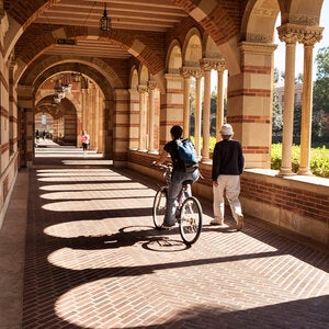 students walking down an arched walkway